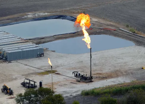 oil and gas produced water holding ponds with flare gas being flared into the air